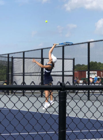 Senior Anna Siesel returns the ball in her tennis match.