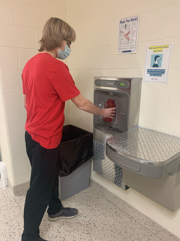 Junior Isaac Bee fills his water bottle at the new filling station in the 1600 hallway.. 