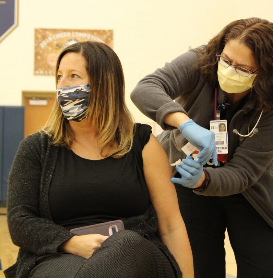 Teacher Julie Headrick nervously looks away while receiving the COVID-19 vaccine Feb. 3 in the Tallmadge High School Gymnasium. “I am always nervous before I get shots, and I felt a lot of emotions in getting this one,” Headrick said.