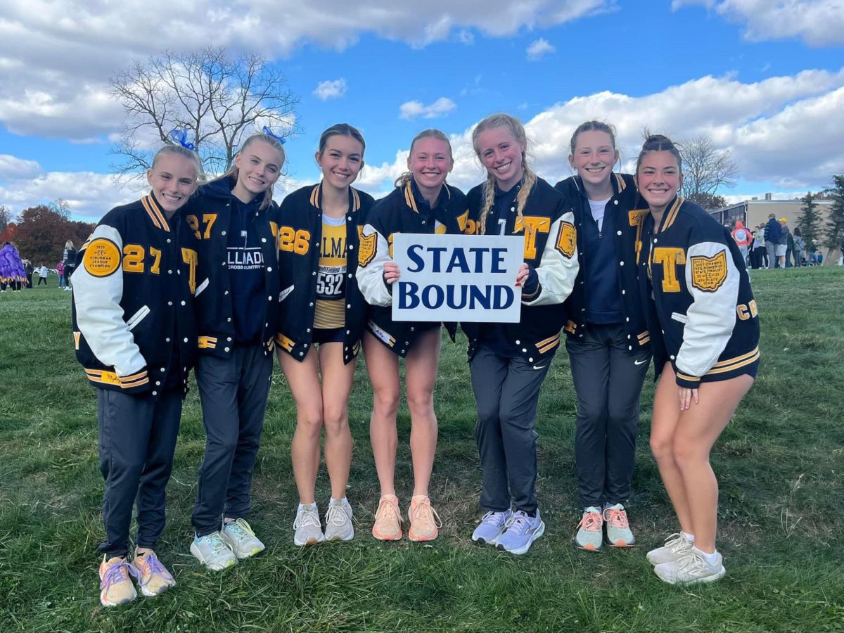 The 2024 Tallmadge girls cross country team poses with their state bound poster the Division II Regional Meet at Boardman High School Oct. 26.